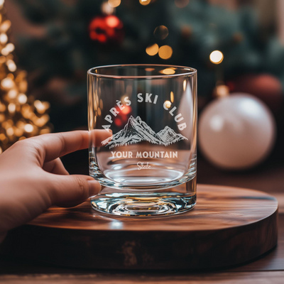 a person is holding a glass with a mountain on it