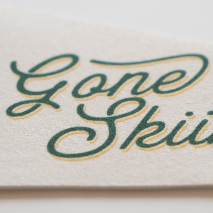 a close-up of a textured surface with the words "Gone Ski" written in a cursive font.