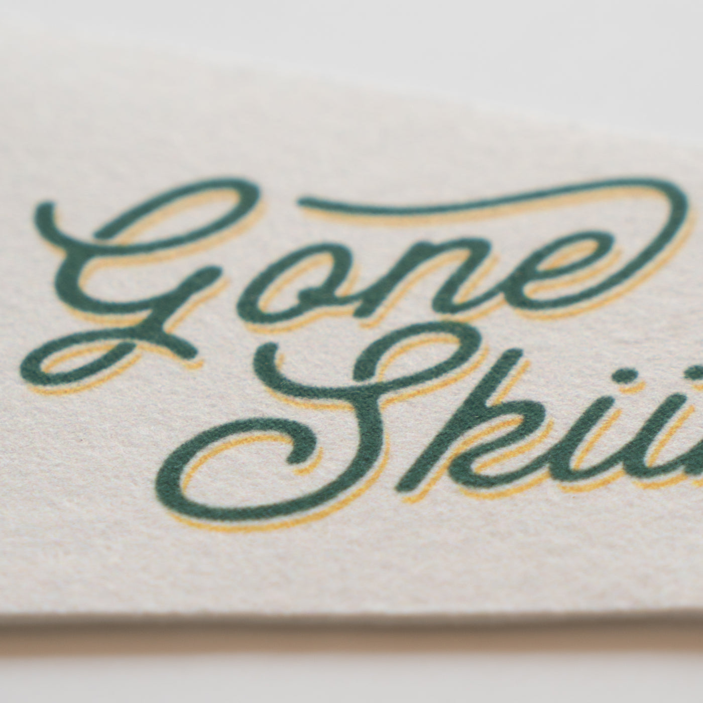 a close-up of a textured surface with the words "Gone Ski" written in a cursive font.