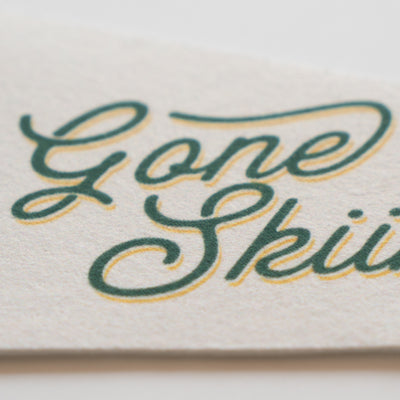 a close-up of a textured surface with the words "Gone Ski" written in a cursive font.