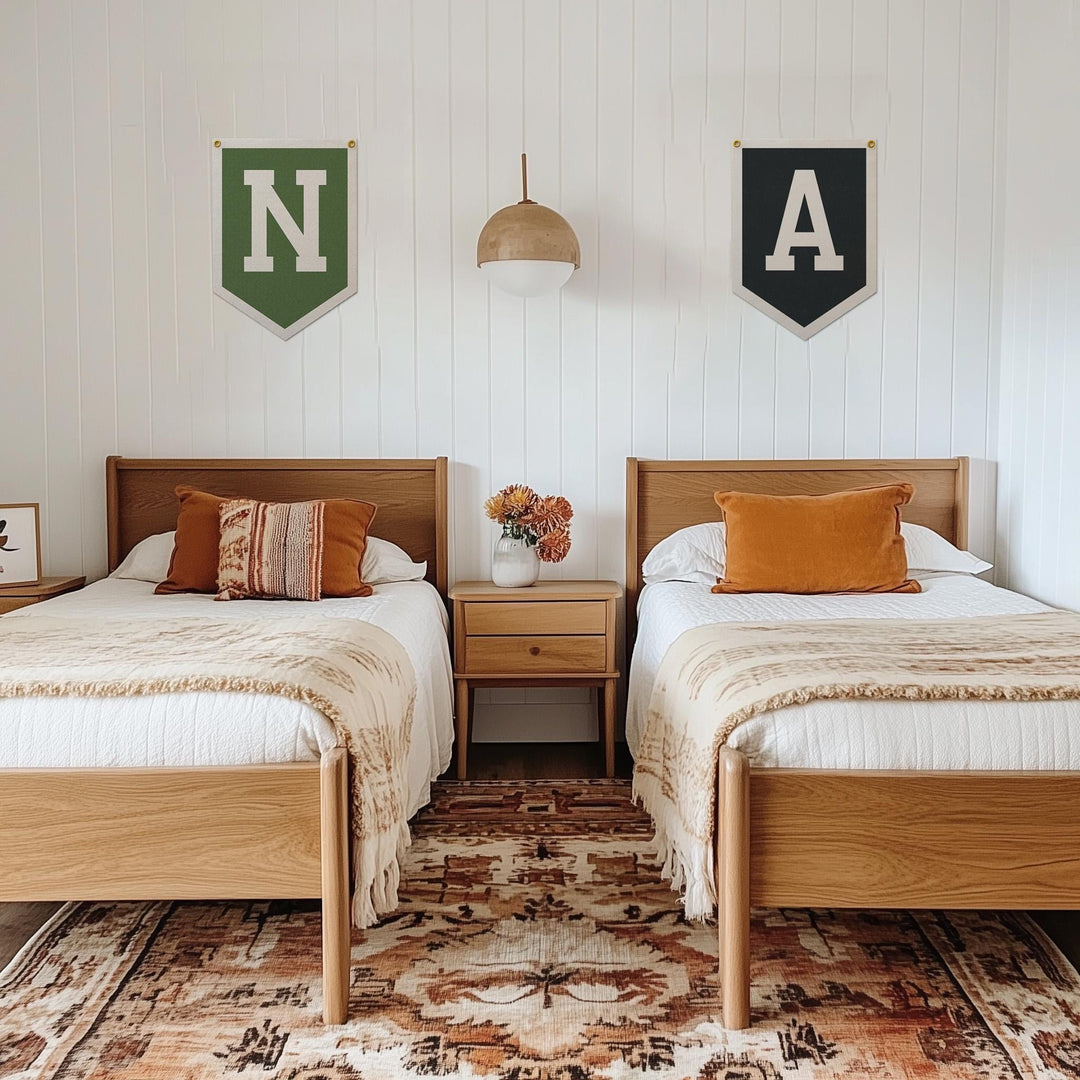 a cozy bedroom with two twin beds, each with a wooden headboard and footboard. The beds are dressed in white linens and have orange throw pillows. Above the beds, there are two green and black banners with the letters &amp;quot;N&amp;quot; and &amp;quot;A&amp;quot; on them. The room also features a wooden nightstand between the beds, with a vase of flowers on top. The floor is covered with a patterned rug.