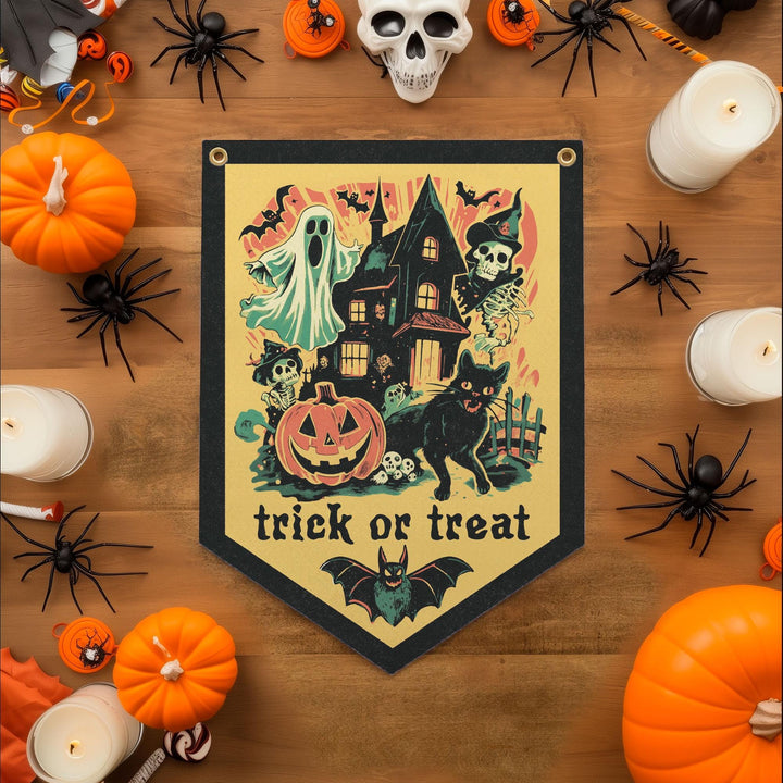 a Halloween-themed banner with a house, bats, a ghost, a jack-o-lantern, and a cat, surrounded by various Halloween decorations such as pumpkins, spider-themed items, and candles.