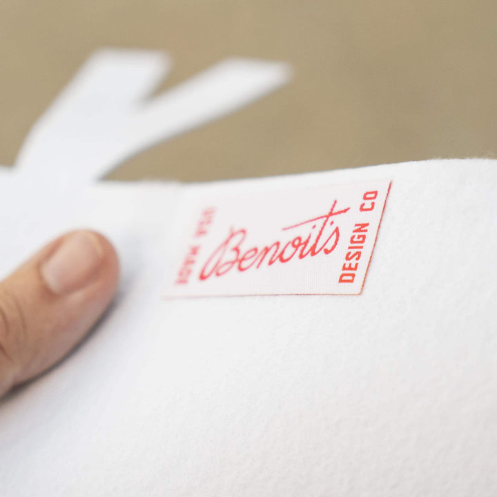 A hand holding a white piece of paper with a red label that says &amp;quot;Benoits DESIGN CO&amp;quot;.