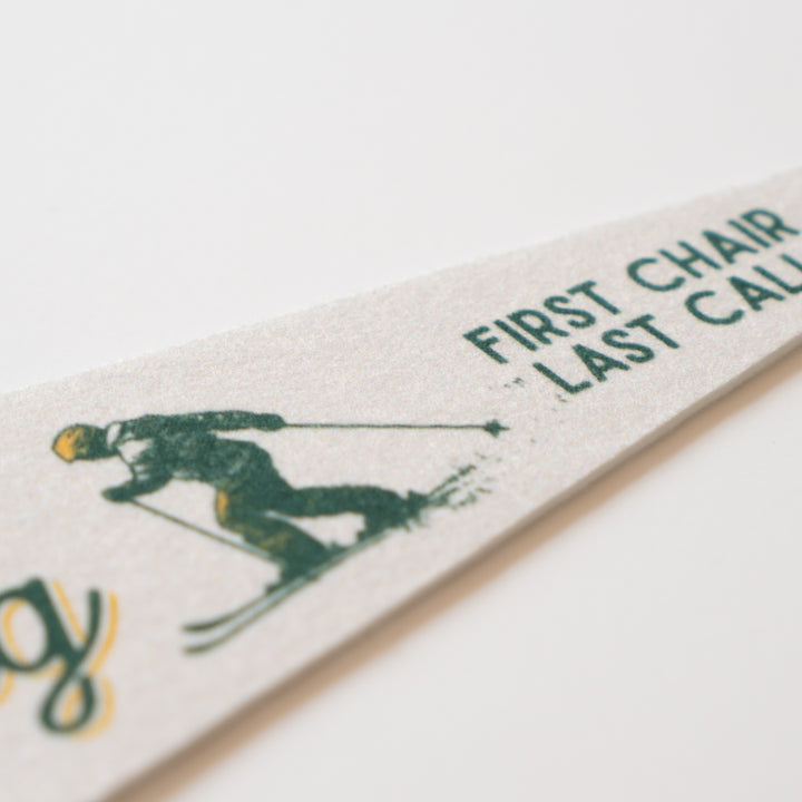 A close-up of a white object with a green and black design depicting a person skiing.