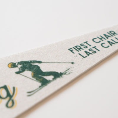 A close-up of a white object with a green and black design depicting a person skiing.