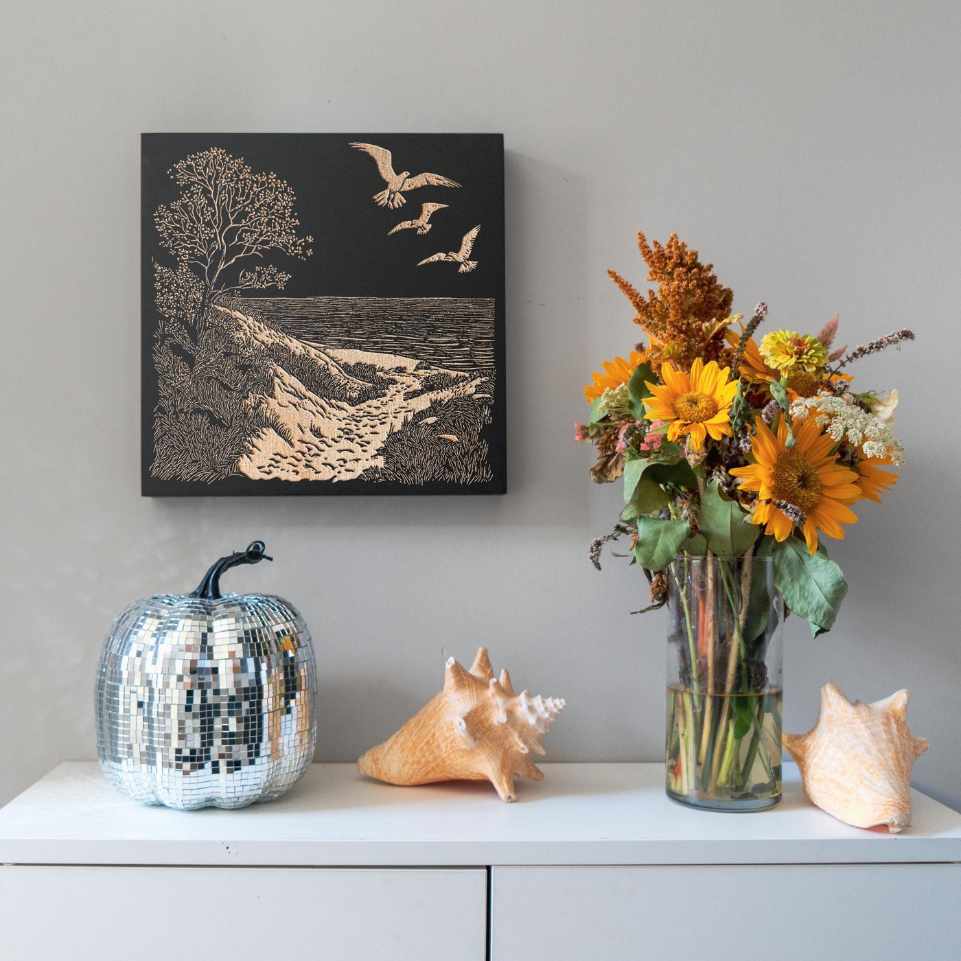 a vase of flowers sitting on top of a white dresser