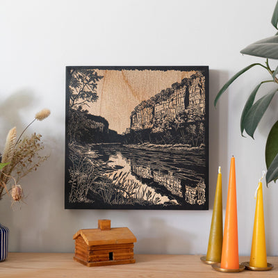 a picture of a river in a wood frame