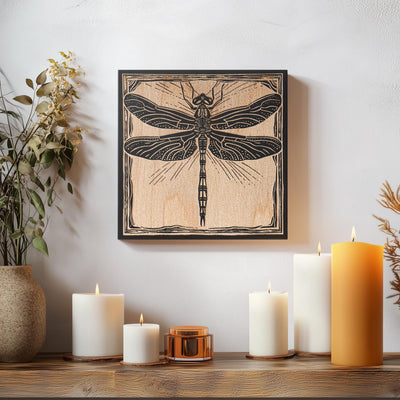 a picture of a dragonfly on a wall next to candles